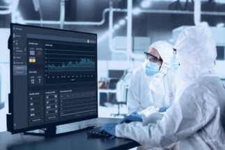 Factory workers utilizing Impact Manager software. 