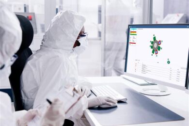 An engineer in a semi fab is using the FabGuard process monitoring and fault detection software system on a computer An engineer in a semi fab is using the FabGuard process monitoring and fault detection software system on a computer