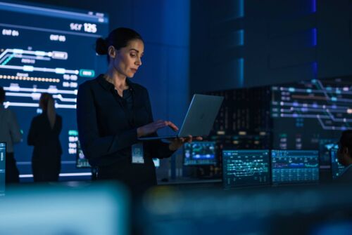 Engineer using laptop in semiconductor fab control room